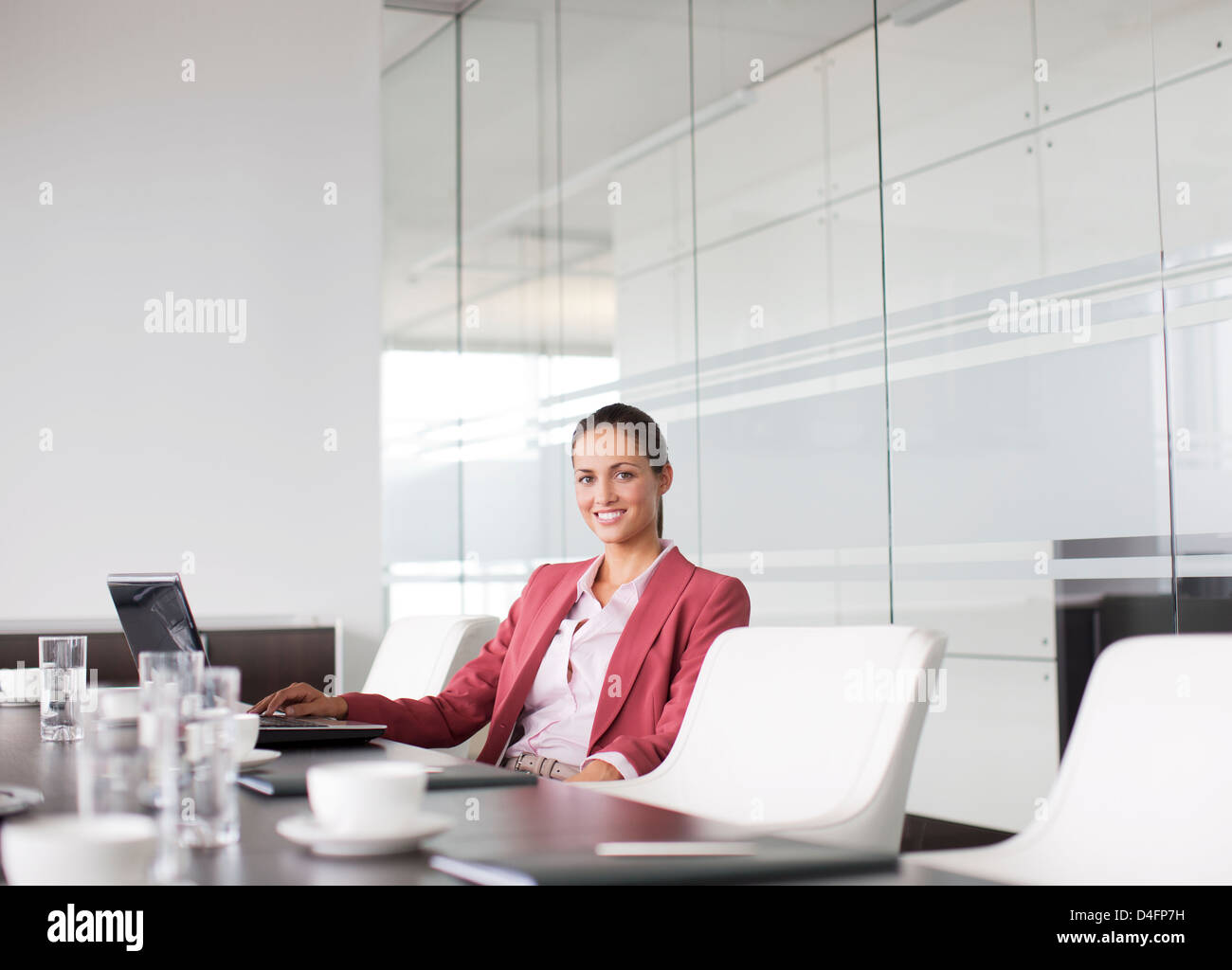 Geschäftsfrau, die lächelnd am Besprechungstisch Stockfoto