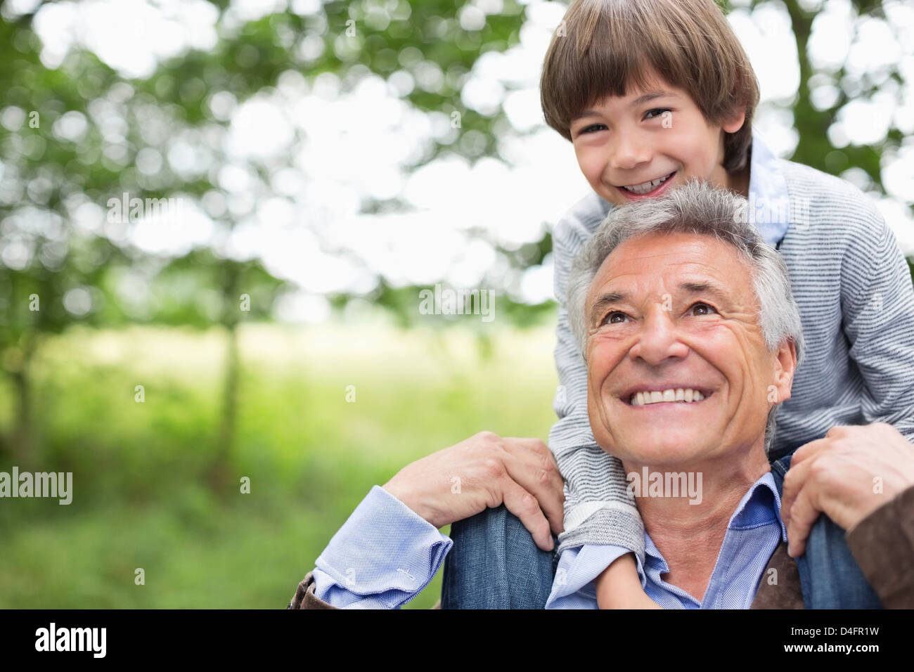 Mann, der Enkel auf seinen Schultern trägt Stockfoto
