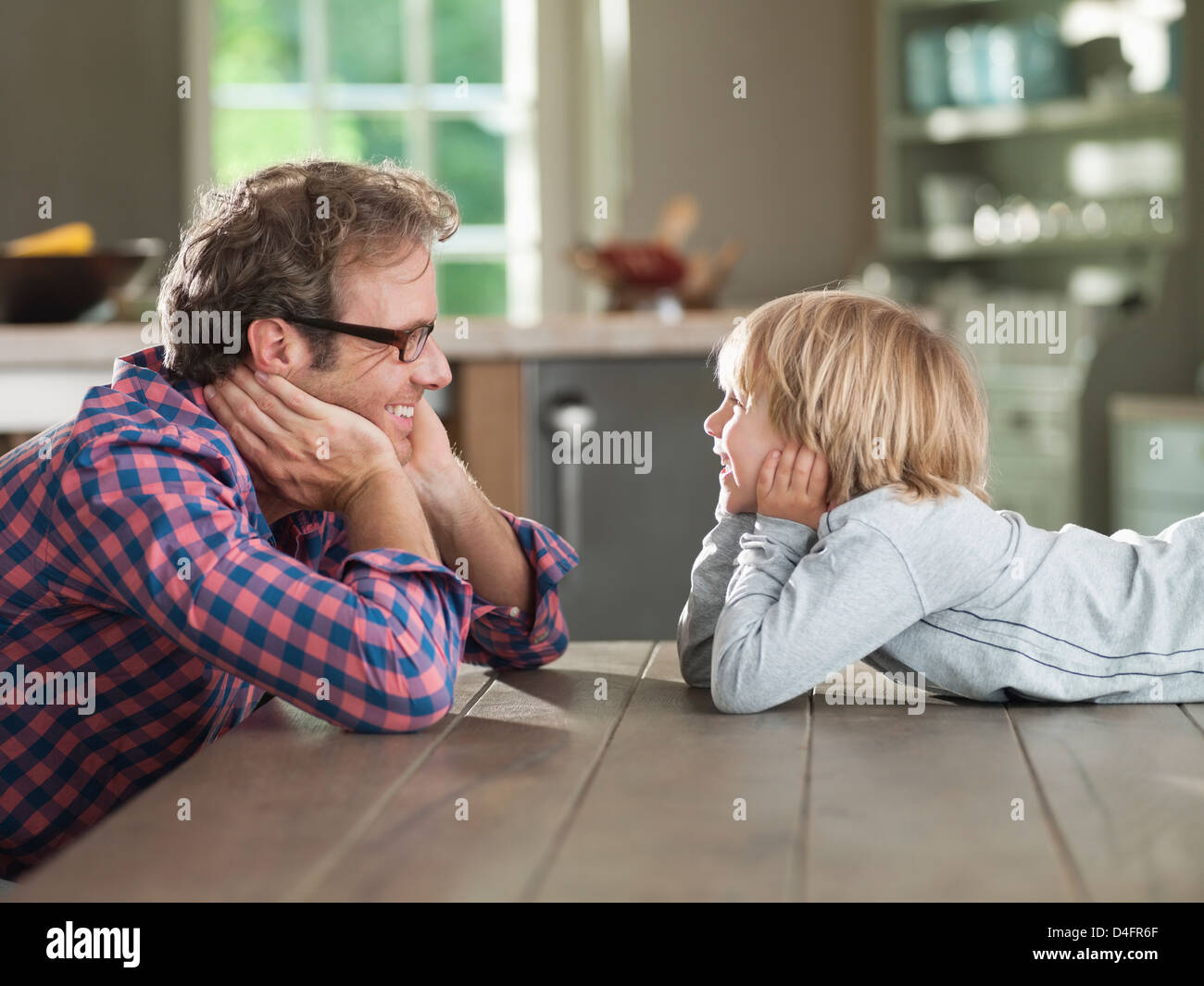 Vater und Sohn bewundern einander am Tisch Stockfoto