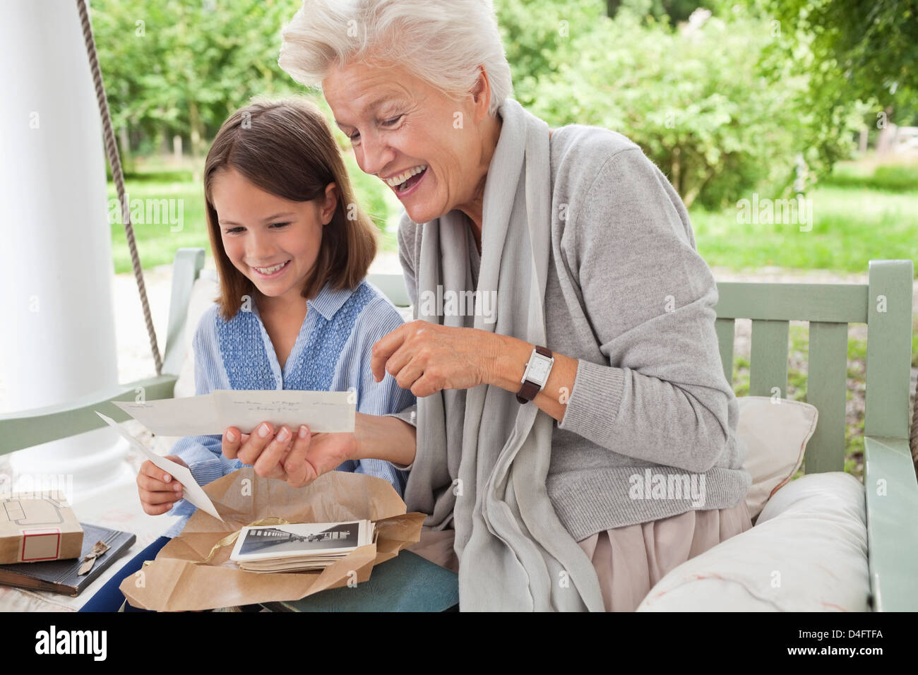 Frau und Enkelin betrachten von Fotos Stockfoto