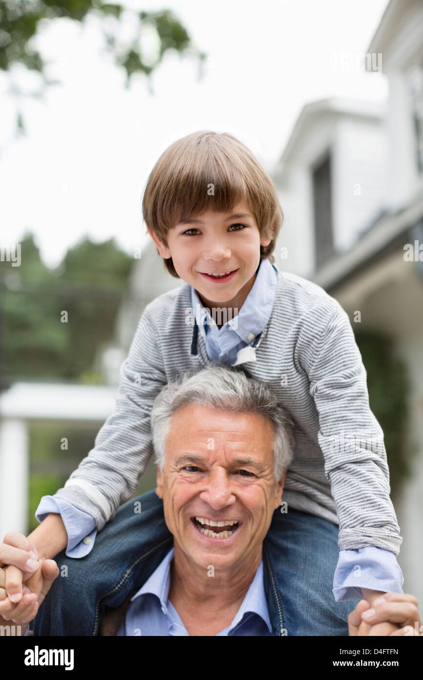 Mann, der Enkel auf seinen Schultern trägt Stockfoto