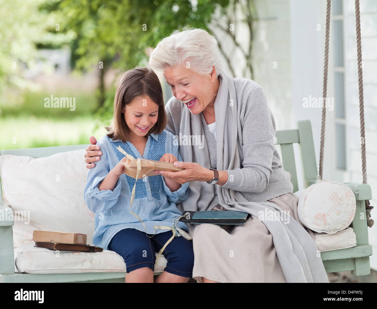 Frau mit Enkelin im Veranda-Schaukel Stockfoto