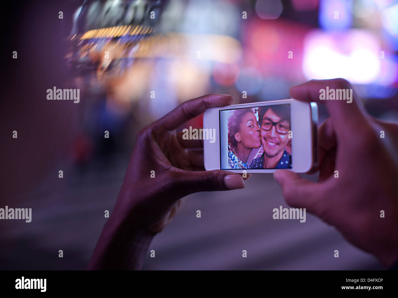 Frau mit Handy mit Foto auf dem Bildschirm Stockfoto
