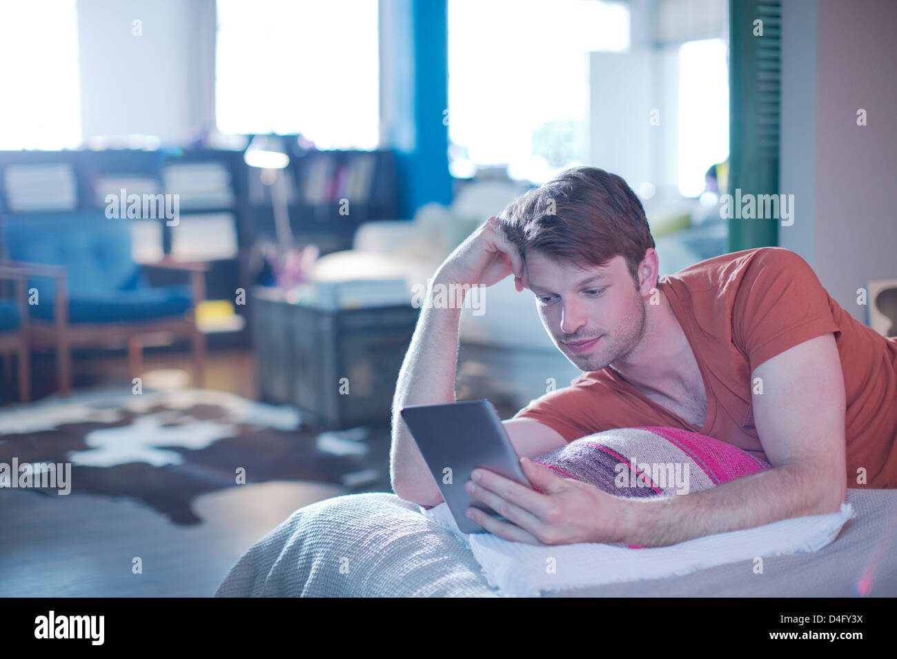 Mann mit digital-Tablette auf Bett Stockfoto
