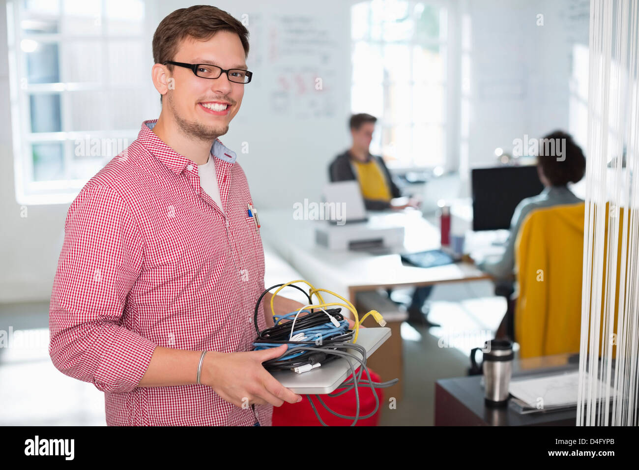 Geschäftsmann mit Kabel und Laptop im Büro Stockfoto