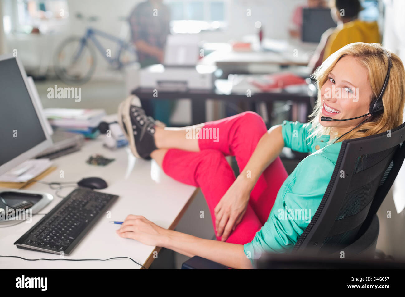 Geschäftsfrau tragen Kopfhörer am Schreibtisch Stockfoto