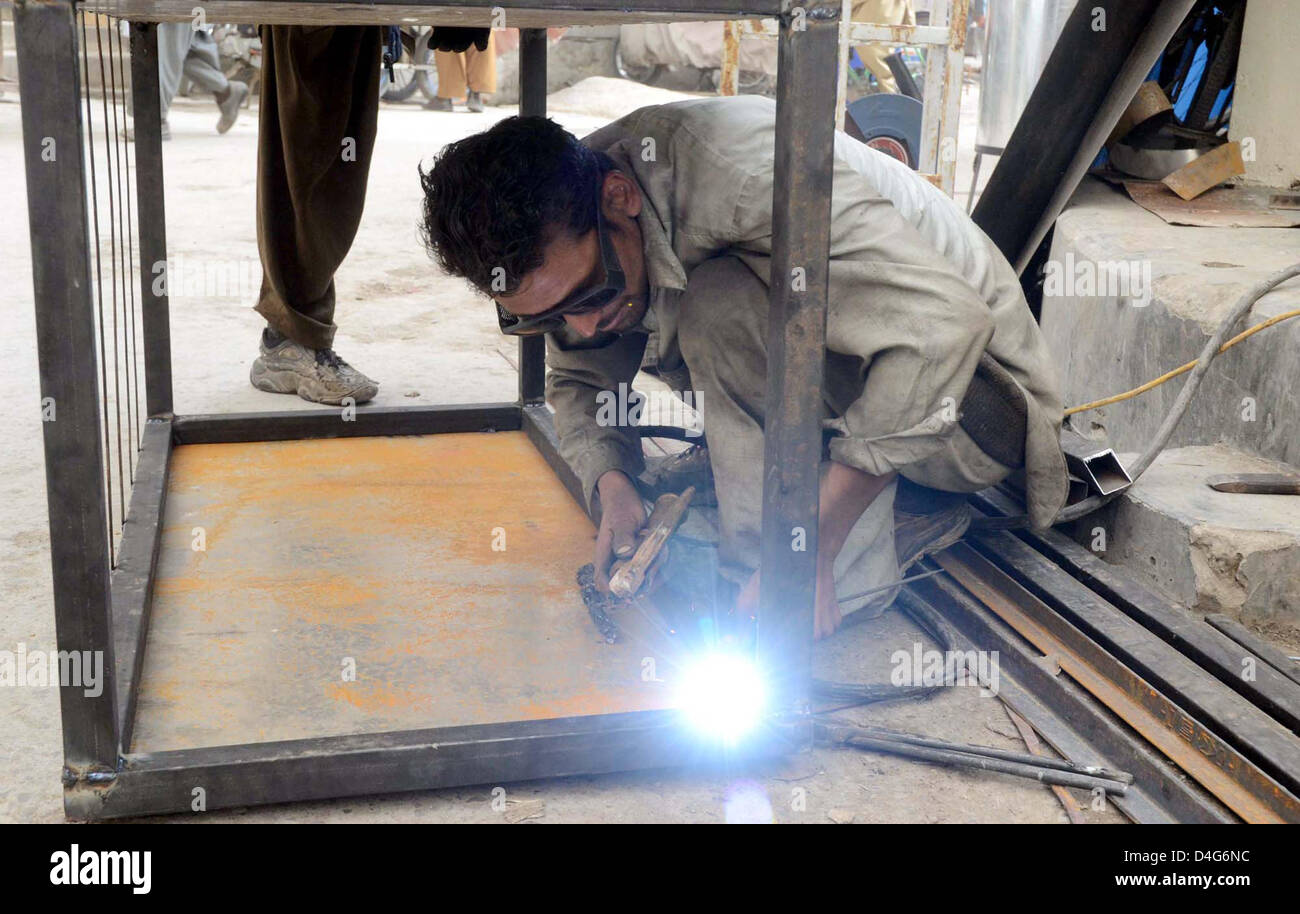 Backsmith beim Schweißen Eisen Winkel um Eisen Feld zu machen, er seinen Lebensunterhalt für die Unterstützung seiner Familie außerhalb seines Arbeitsplatzes in Quetta auf Mittwoch, 13. März 2013 verdient, beschäftigt. Stockfoto
