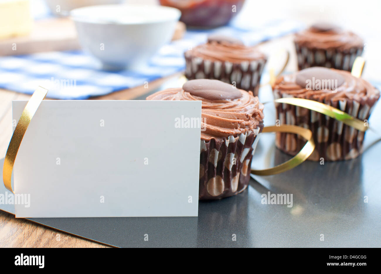 Leckere Schokolade Ostern Muffins auf ein Backblech mit einem Goldband Dekoration und leere Karte Stockfoto