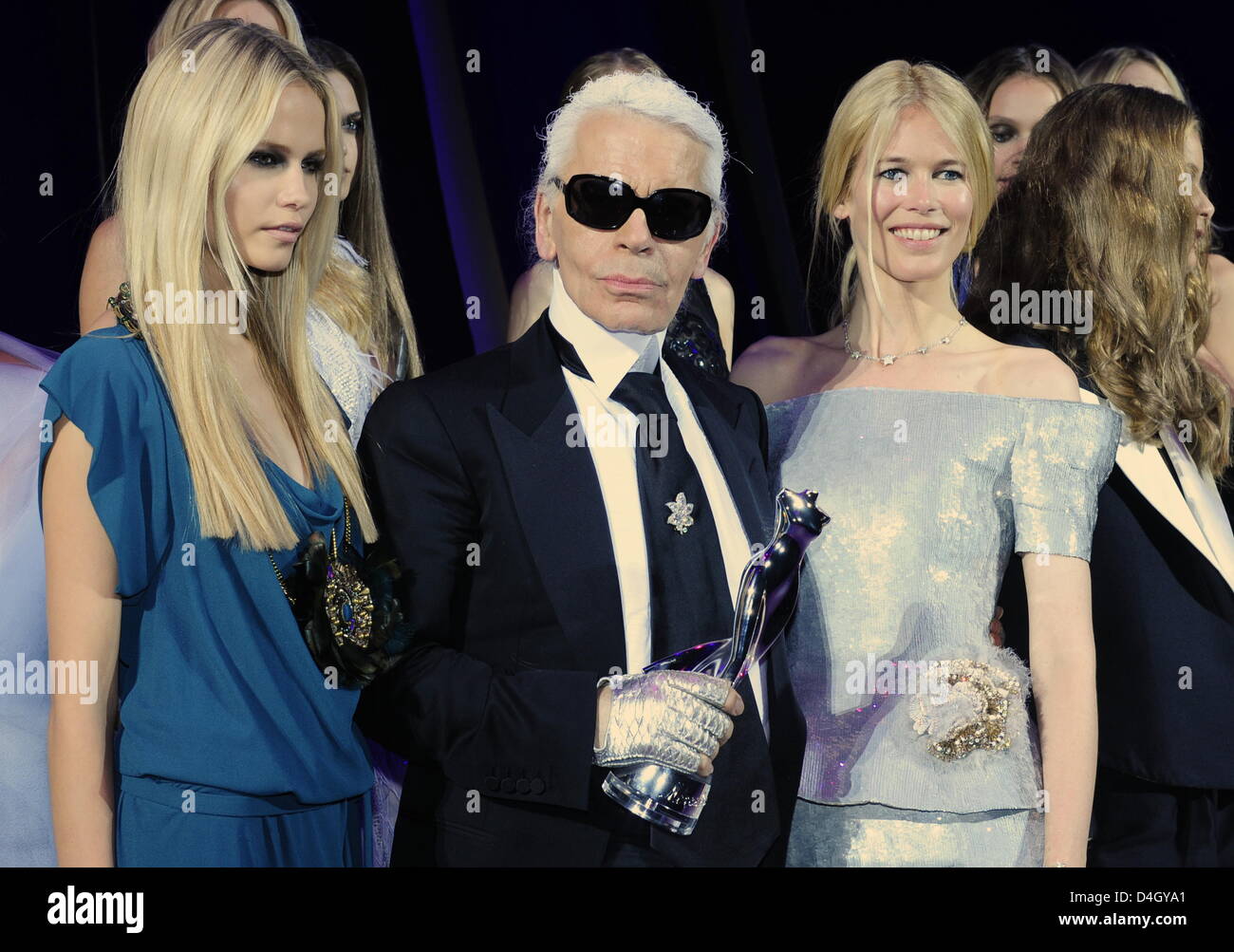 Deutscher Modedesigner Karl Lagerfeld (C) ist mit dem deutschen Modell Claudia Schiffer (R) und Russische Model Natasha Poly (L) abgebildet, wie er seine Auszeichnung, der "Mercedes Platinum" in seinen Händen nach der Verleihung des "Elle Fashion Star Award" in Berlin, Deutschland, 19. Juli 2008 hält. Zum ersten Mal das Magazin ausgezeichnet herausragende Mitglieder der internationalen Modeszene während der Stockfoto