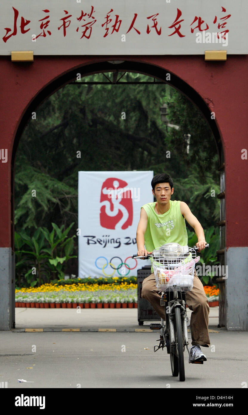 Ein Mann Zyklen hinter dem Olympia-Logo "Tanzen Peking" in Peking, China, 28. Juli 2008. Der diesjährigen Olympischen Spiele beginnen am 8. August 2008. Foto: GERO BRELOER Stockfoto