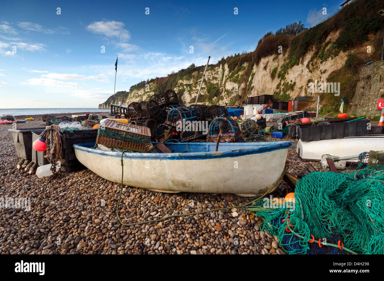 Ein Fischerboot mit Netzen und Hummer Töpfe am Strand von Bier an der Jurassic Coast in Devon Stockfoto