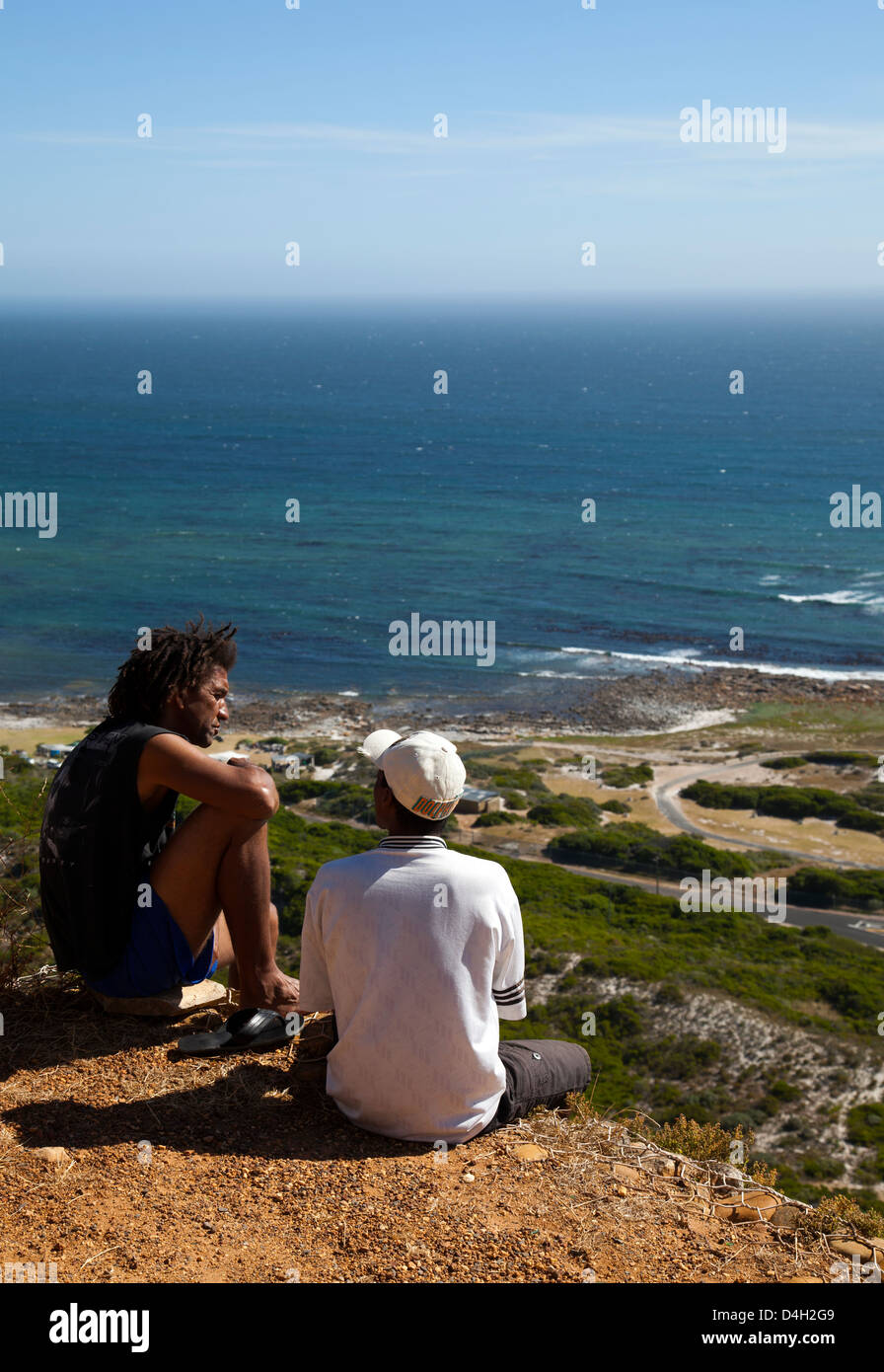 Zwei lokale Jungs sitzen am Straßenrand Flanke am Slangkop - western Cape - Südafrika Stockfoto