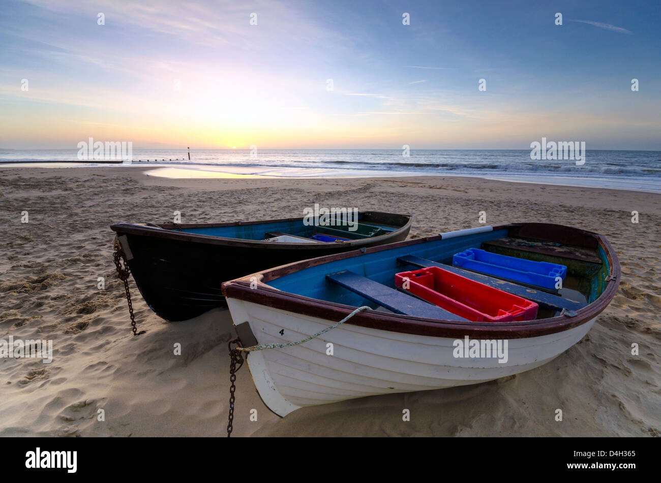 Angelboote/Fischerboote auf dem Sand am Strand von Bournemouth in Dorset bei Sonnenaufgang. Stockfoto