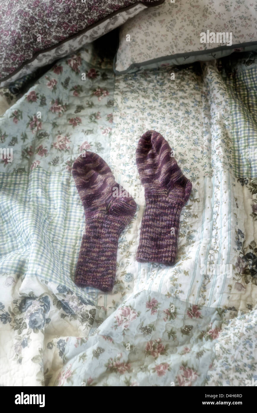 Handgestrickte Socken auf einem Vintage Bett Stockfoto