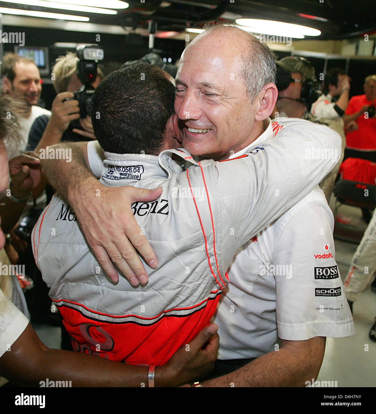 Britische Formel1-Fahrer Lewis Hamilton (C) of McLaren Mercedes feiert seine Meisterschaft mit McLaren-Team, die wichtigsten britischen Ron Dennis (R) in das Team der Garage nach der F1 Grand Prix von Brasilien auf der Rennstrecke verfolgen in Interlagos bei Sao Paulo in Brasilien, 2. November 2008. Hamilton wurde 5. und gewann den Titel. Foto: ROLAND WEIHRAUCH Stockfoto