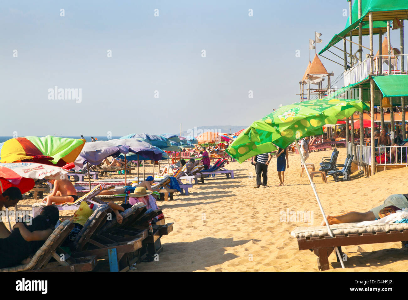 Horizontale Aufnahme an einem belebten Strand von Urlaubern und Urlauber entspannen und chillen in Goa Indien Stockfoto