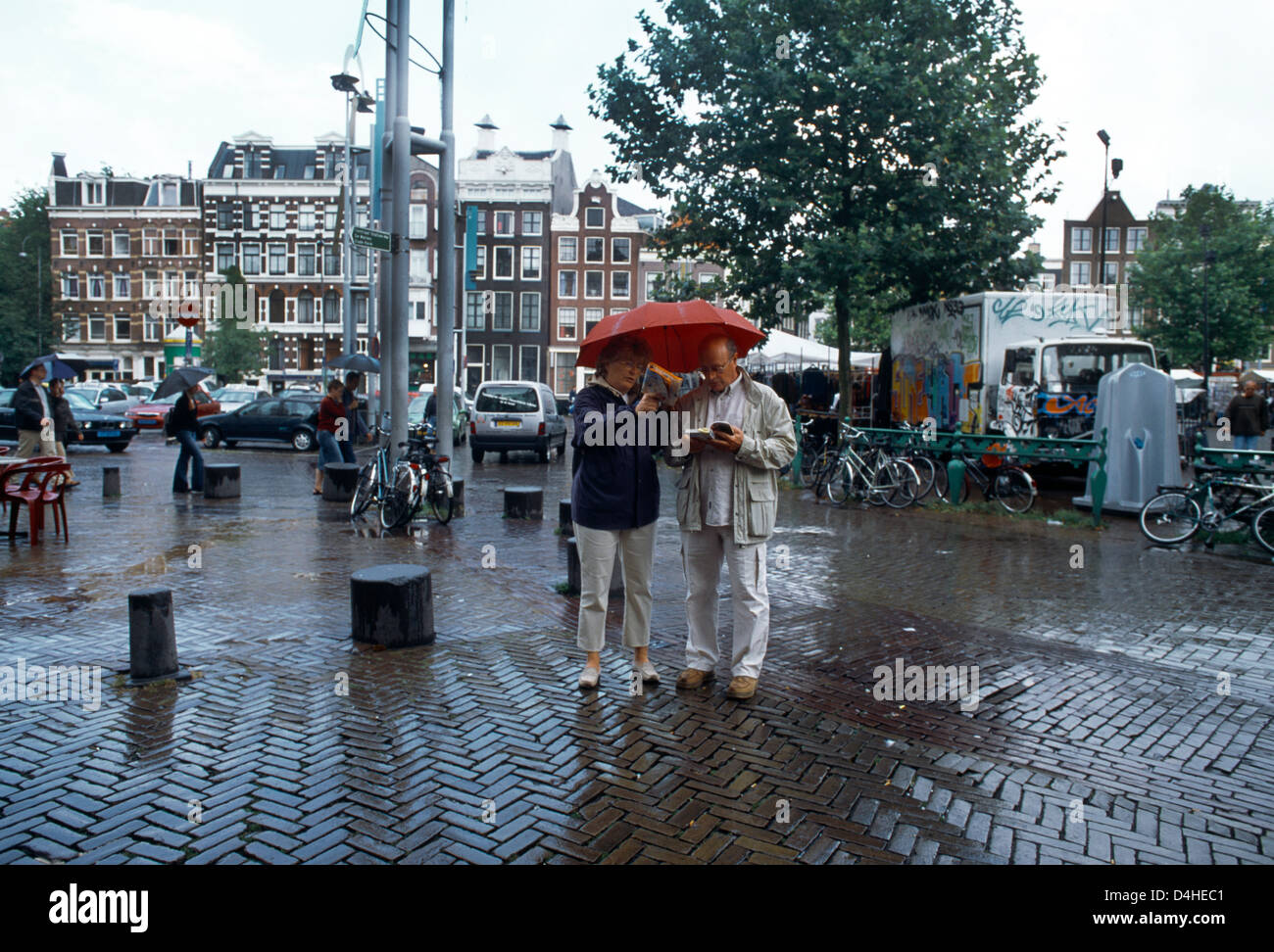 Amsterdam Holland paar im Regen mit Regenschirm betrachten Reiseführer Stockfoto