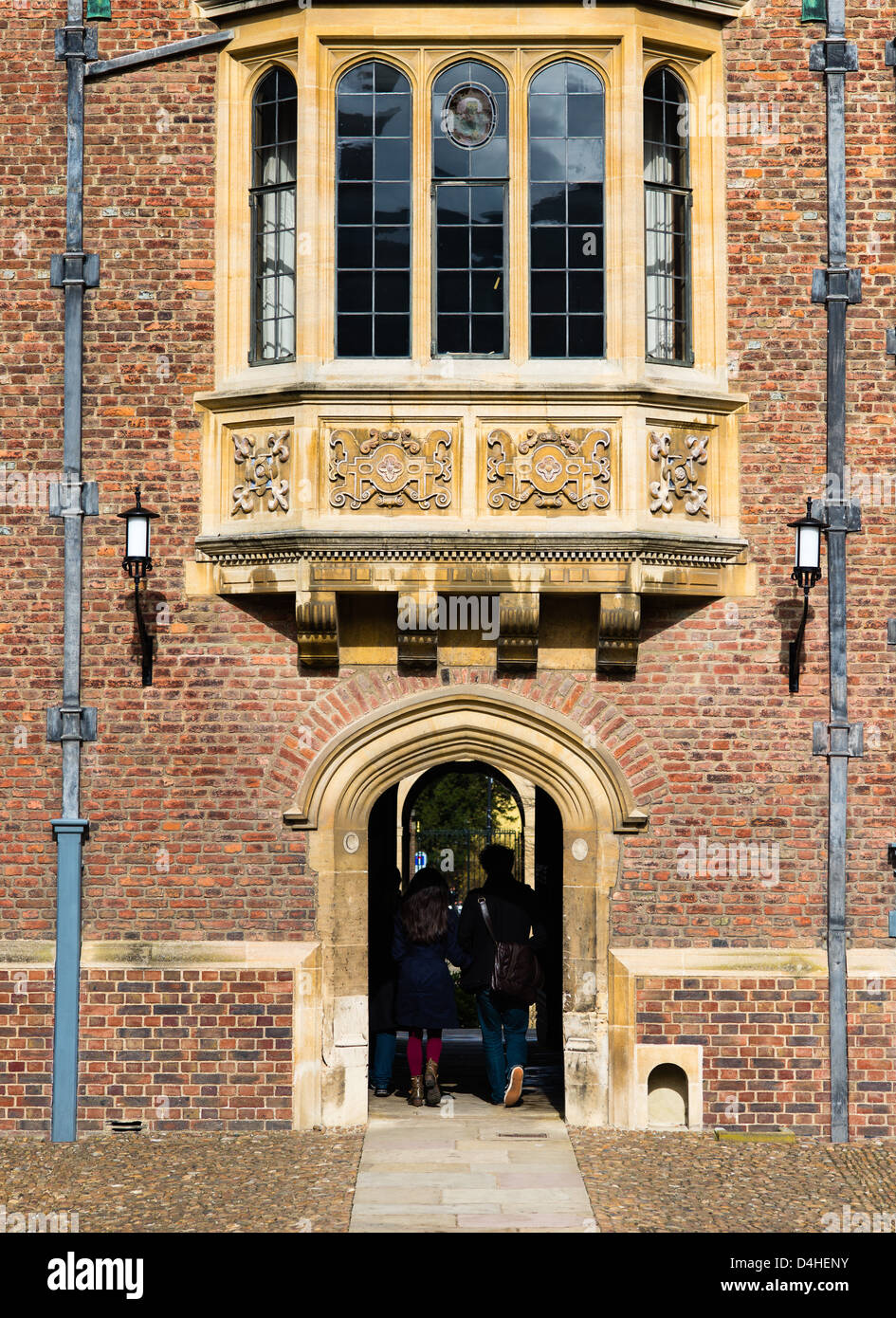 Zwei Studenten, die durch einen Torbogen am mittelalterlichen College of St. John's, Universität Cambridge, England. Stockfoto