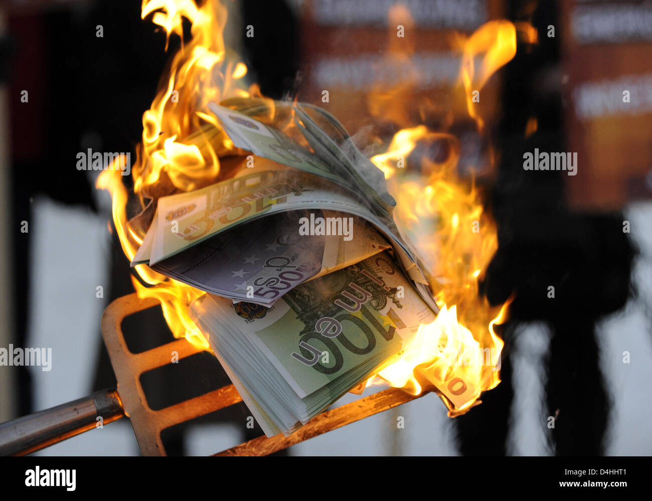 Demonstranten verbrennen gefälschte Banknoten vor dem Bundeskanzleramt in Berlin, Deutschland, 12. Januar 2009. Das zweite Paket der Belebung der Wirtschaft werden am Nachmittag in der Kanzlei besprochen. Freuen Sie sich auf zusätzliche Investitionen in die Infrastruktur sowie eine Reduzierung der Steuern und Abgaben. Die Demonstranten fürchten das Geld der Steuerzahler zu? verbrannt? durch das Paket. Foto: R Stockfoto
