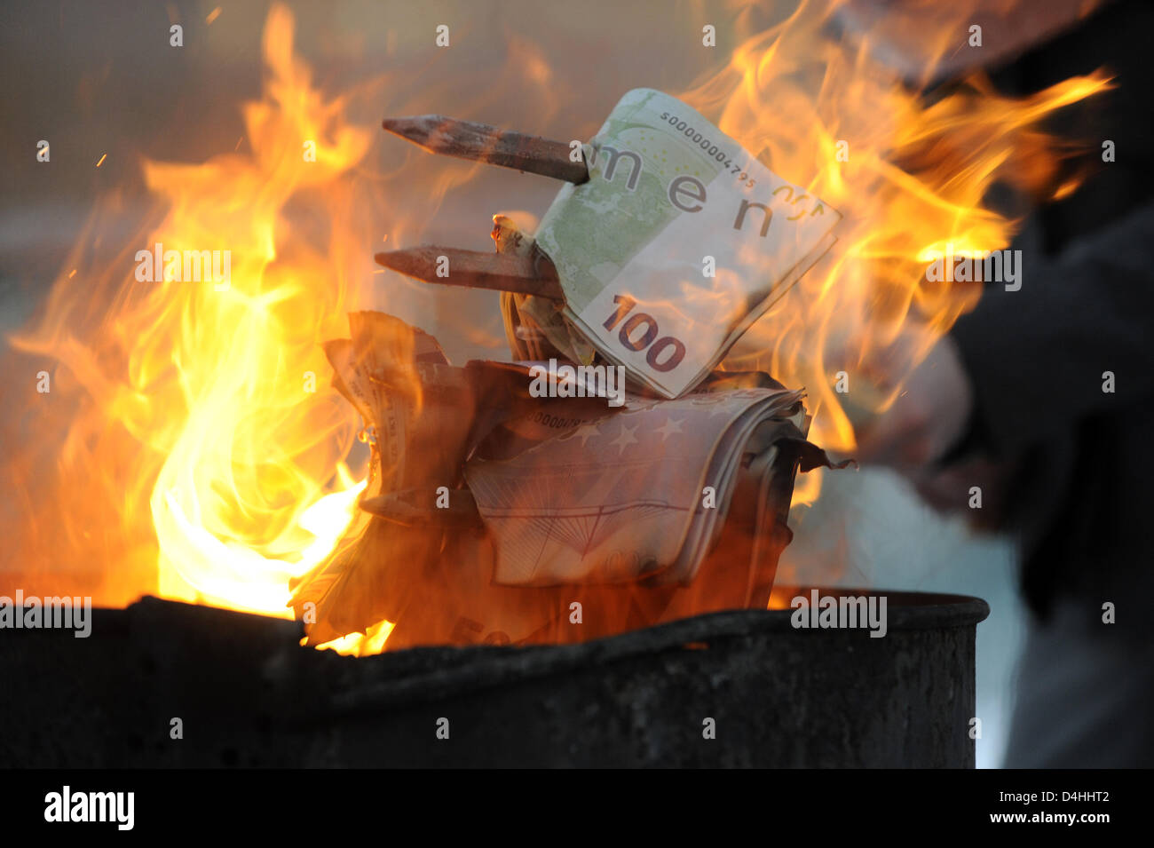 Demonstranten verbrennen gefälschte Banknoten vor dem Bundeskanzleramt in Berlin, Deutschland, 12. Januar 2009. Das zweite Paket der Belebung der Wirtschaft werden am Nachmittag in der Kanzlei besprochen. Freuen Sie sich auf zusätzliche Investitionen in die Infrastruktur sowie eine Reduzierung der Steuern und Abgaben. Die Demonstranten fürchten das Geld der Steuerzahler zu? verbrannt? durch das Paket. Foto: R Stockfoto