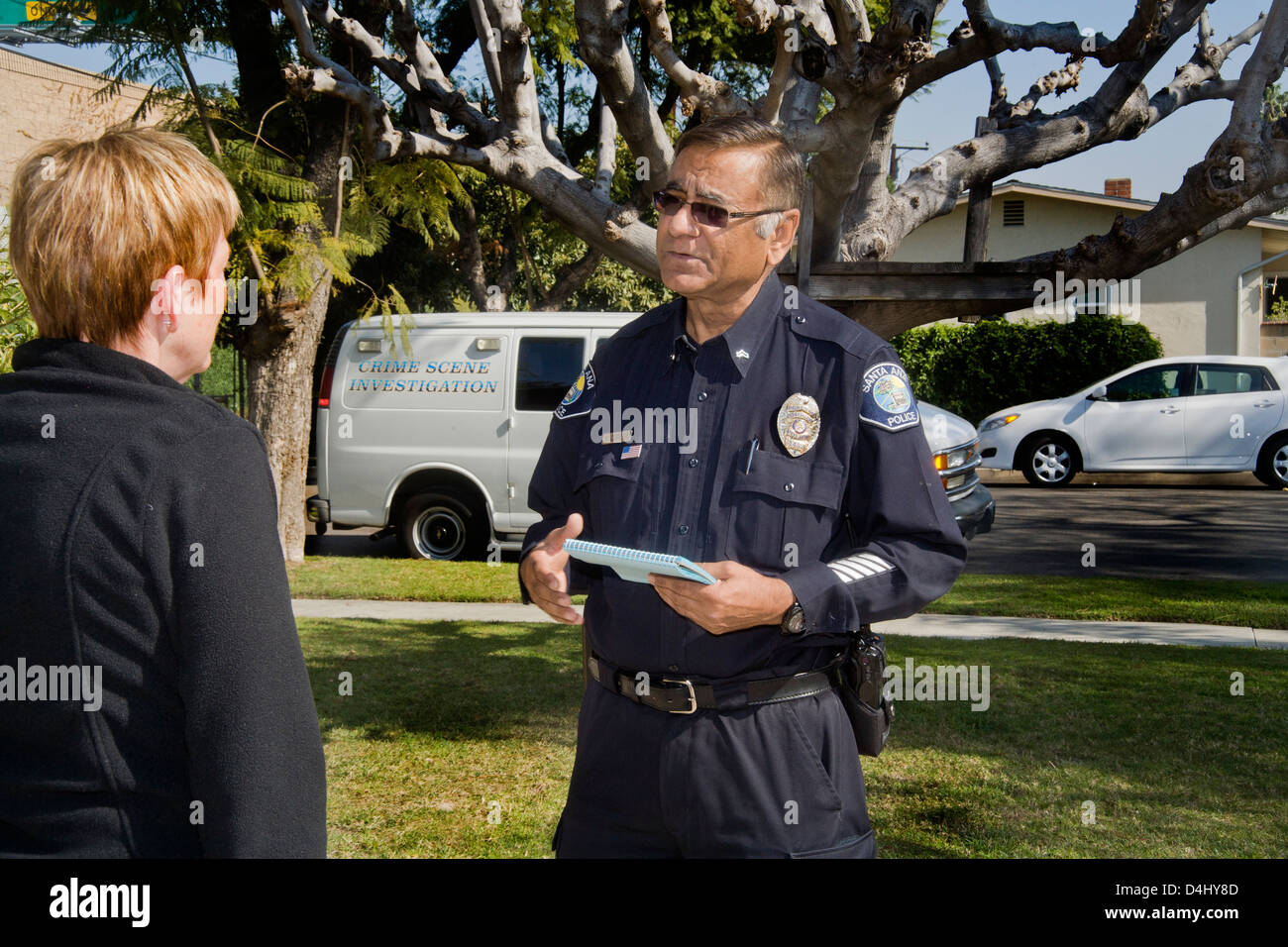 Nach dem sammeln forensische Beweise pakistanisch-amerikanische Polizei Kriminalität Szene Ermittler Gespräche mit dem Besitzer eines Hauses in gebrochen Stockfoto
