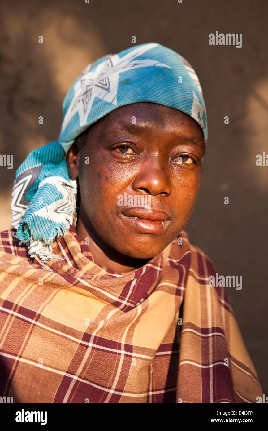Afrikanische Frau zu Hause in ihrem Dorf, Mosambik. Sie ist in einem schlechten Gesundheitszustand und hat Besuch von einer Pflegekraft zu unterstützen. Stockfoto