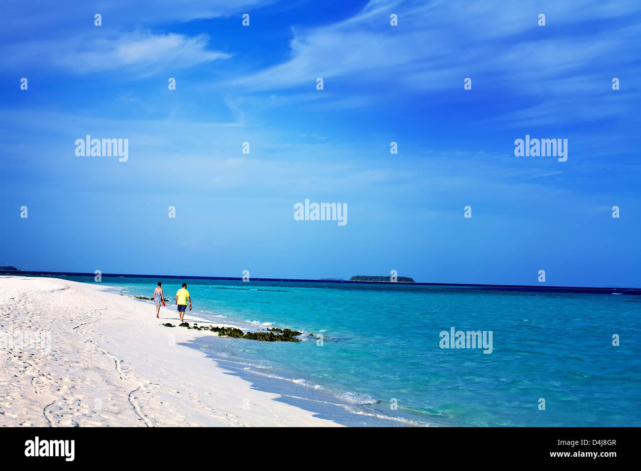 Landschaftsfoto von romantischen senior Mann und Frau Brautpaar zu Fuß an einem tropischen Strand mit strahlend blauem Himmel Stockfoto