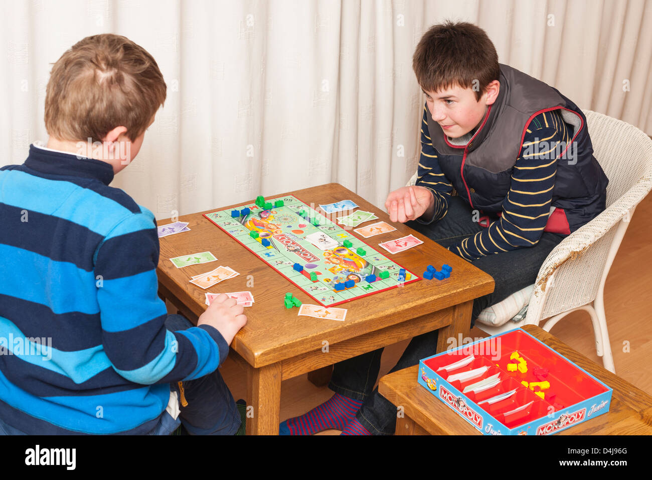 Zwei Jungs (Brüder) junior Monopoly Brettspiel zu Hause spielen Stockfoto