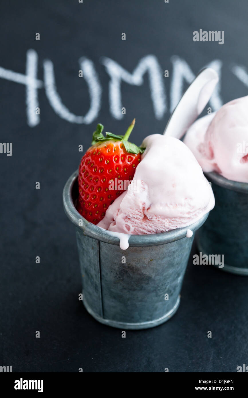 Nahaufnahme von Erdbeereis und Erdbeere mit Kreide geschriebene Wort auf dunklem Hintergrund Stockfoto