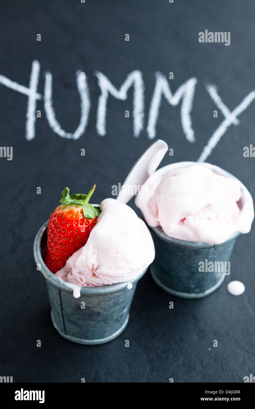 Nahaufnahme von Erdbeereis und Erdbeere mit Kreide geschriebene Wort auf dunklem Hintergrund Stockfoto