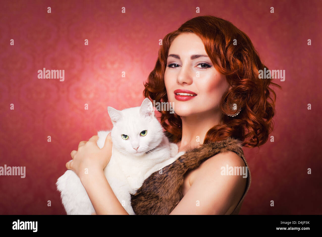 rote wunderschöne Mädchenmode mit weiße flauschige Katze Stockfoto