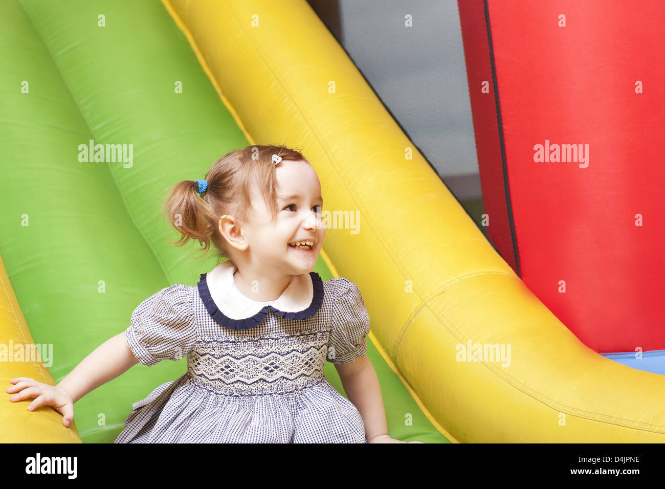 kleines Mädchen auf Spielplatz Folie lacht Stockfoto