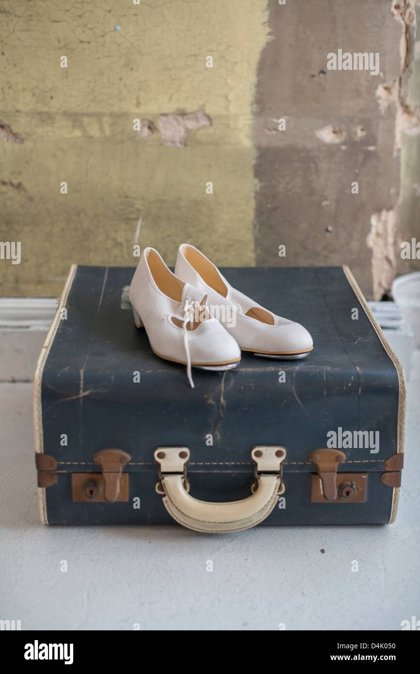 Schuhe, die sitzen auf antike Koffer Stockfoto