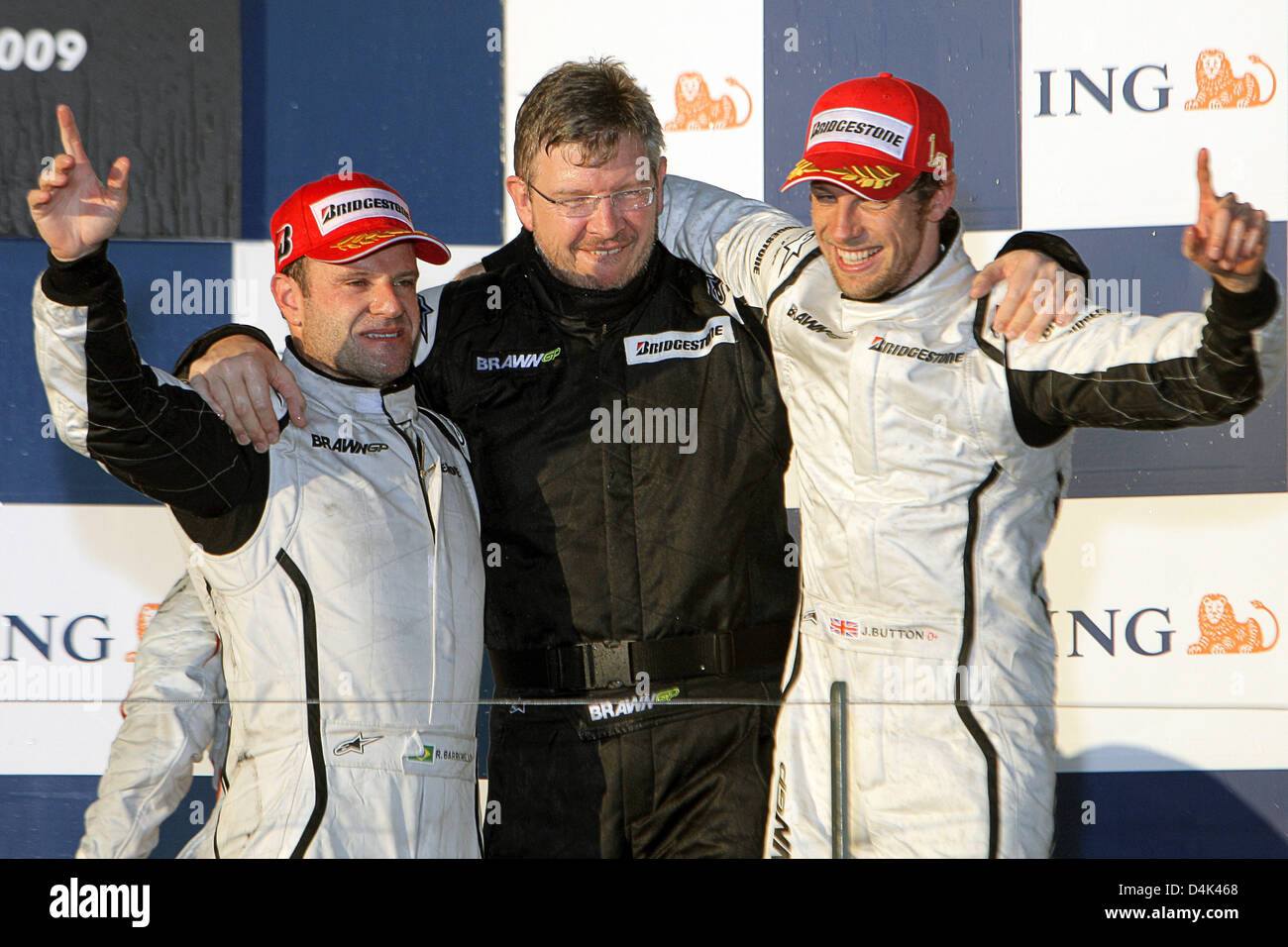 Britische Formel1-Fahrer Jenson Button (R) von Brawn GP und seinem brasilianischen Teamkollegen Rubens Barrichello (L) feiern nach dem Gewinn der ersten und zweiten Platz in der australischen Formel Eins Grand Prix im Albert Park Circuit in Melbourne, 29. März 2009 mit Brawn GP Eigentümer Ross Brawn (C) auf dem Podium. Schaltfläche "fertig" folgten zunächst von seinem brasilianischen Teamkollegen Barrichello und italienischen für Stockfoto