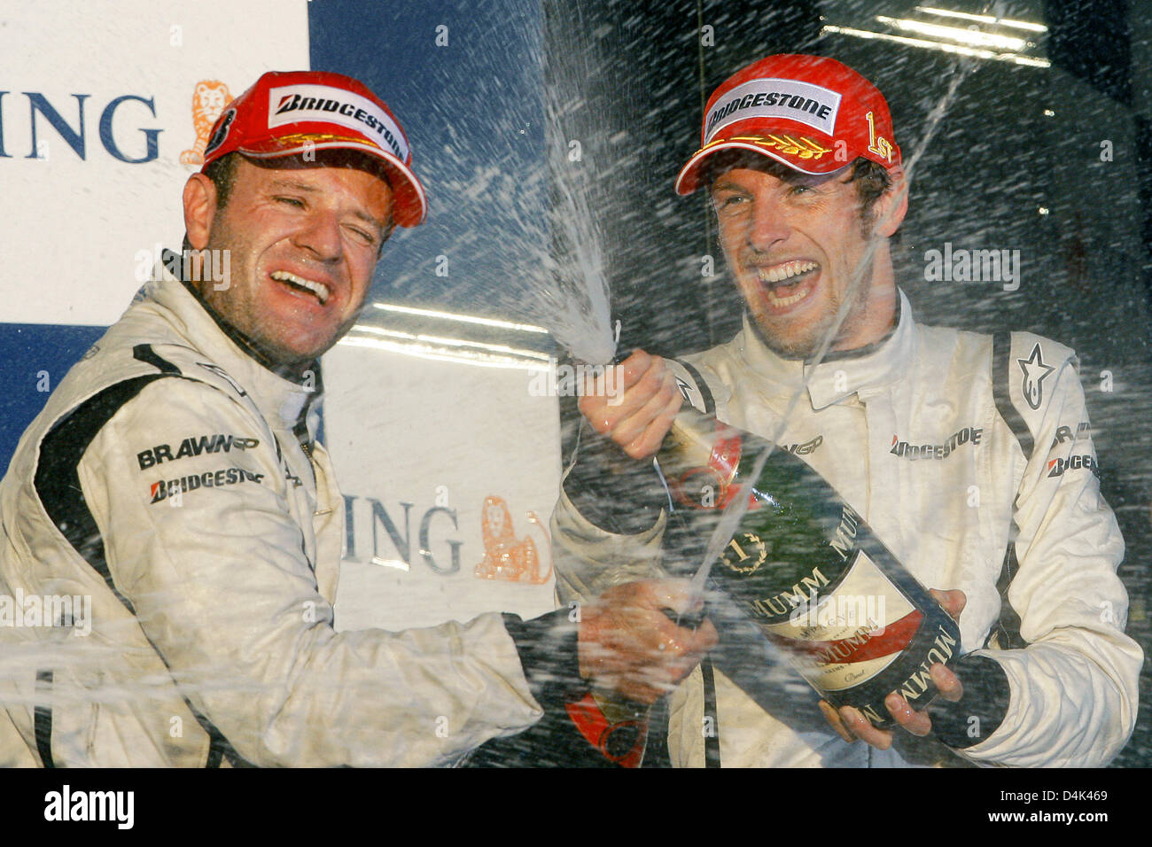 Britische Formel1-Fahrer Jenson Button (R) von Brawn GP und seinem brasilianischen Teamkollegen Rubens Barrichello (L) auf dem Podium am Ende des Australian Formula One Grand Prix im Albert Park Circuit in Melbourne, 29. März 2009 zu feiern. Schaltfläche fertig zuerst gefolgt von brasilianischen Teamkollegen Barrichello im zweiten und italienischer Formel-1-Pilot Trulli Toyota Dritter. Foto: Rol Stockfoto