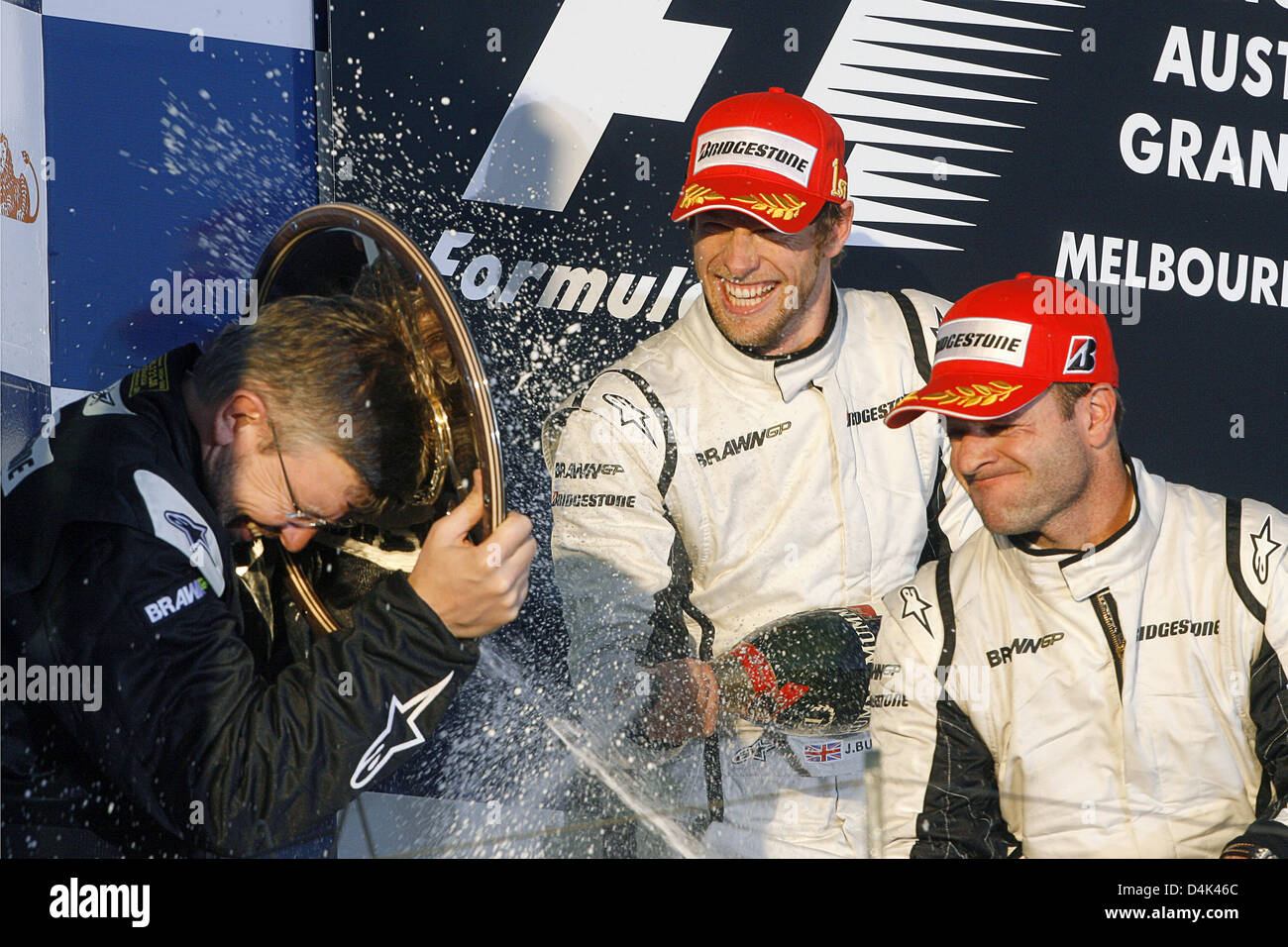 Britische Formel1-Fahrer Jenson Button (C) der Brawn GP und seinem brasilianischen Teamkollegen Rubens Barrichello (R) feiern nach dem Gewinn der ersten und zweiten Platz in der australischen Formel Eins Grand Prix im Albert Park Circuit in Melbourne, 29. März 2009 mit Brawn GP Besitzer Ross Brawn (L) auf dem Podium. Schaltfläche "fertig" folgten zunächst von seinem brasilianischen Teamkollegen Barrichello und italienischen für Stockfoto