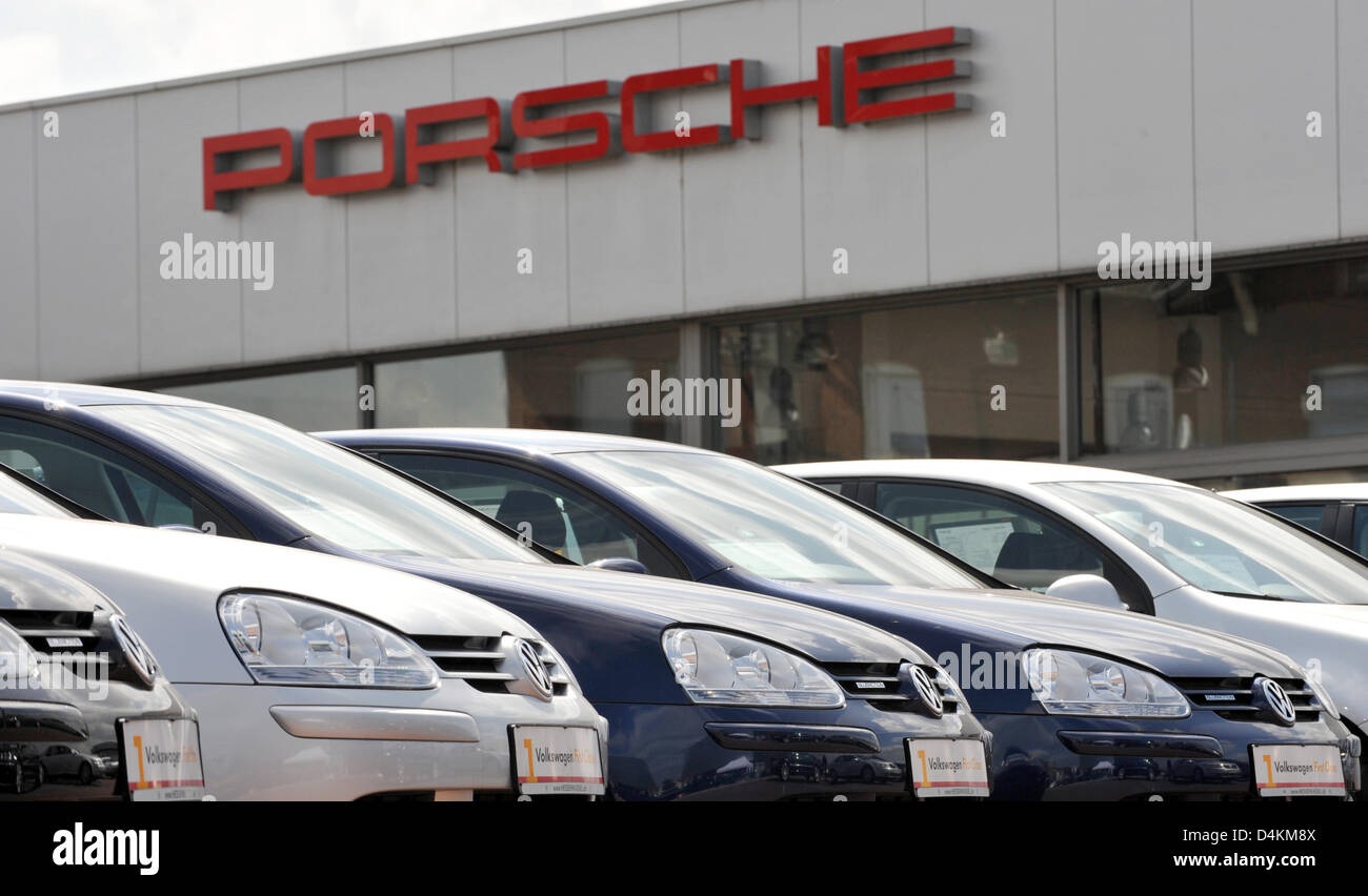 VW Autos stehen vor einem Porsche Schriftzug bei einem Autohändler in Kassel, Deutschland, 7. Mai 2009. Am 06 Mai beschlossen die Familien Porsche und Piëch der beabsichtigten Fusion mit VW zu unterlassen und stattdessen Schaffung ein integriertes Automobilkonzerns. Wie folgt zusammengefasst, sollen die dann zehn Marken des Unternehmens unabhängig zu bleiben. Foto: Uwe Zucchi Stockfoto