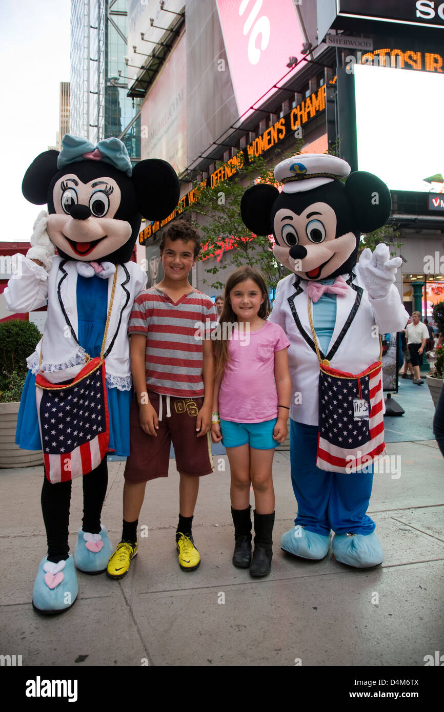 Mickey und Minnie Mouse Cartoon Charakter Kostüme posiert mit Kindern am Times Square, New York Stockfoto