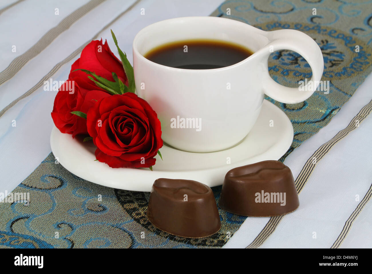 Tasse Kaffee, rote Rosen und milchige Schokolade Stockfoto