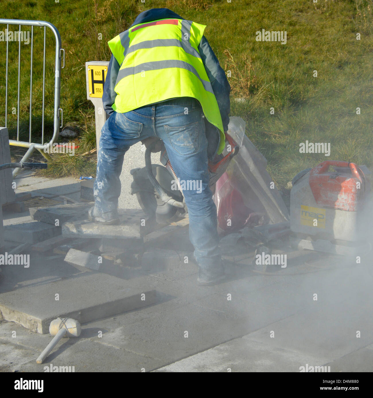 Arbeiter mit einem tragbaren Mauerwerk sah Maschine zum Schneiden von Pflaster Platte (Name aus Jacke entfernt) Stockfoto