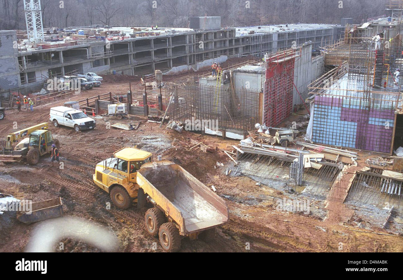 Eine Ansicht, die die Vorbereitung des Mattenfundaments und die Nordfassade eines im Bau befindlichen Garagengebäudes zeigt. Dieses Foto zeigt die Bautätigkeiten in der Anfangsphase, die sich speziell auf Fundamentarbeiten und Baustrukturen konzentrieren. Stockfoto