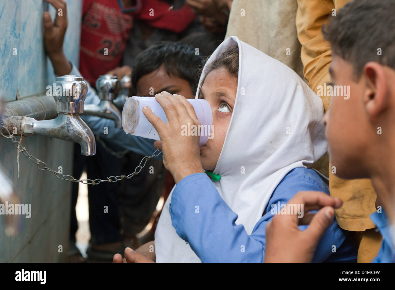 Usman Kurea trinken, Pakistan, Kinder aus einem Trinkwasser-Behälter Stockfoto