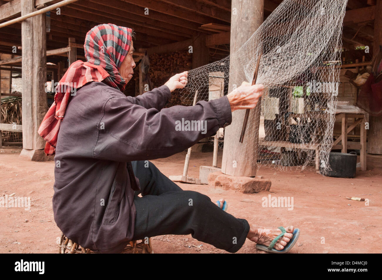 ethnische Khmu Mann seine Fischerei ausbessern Netze, Luang Nam Tha, Laos Stockfoto