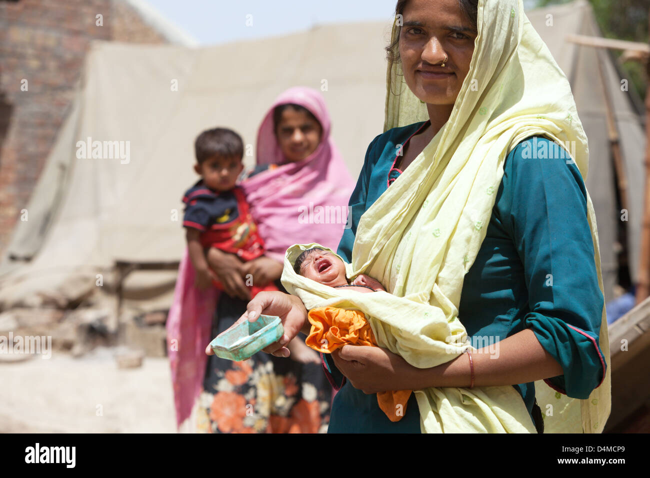 Basti Mumgani, Pakistan, Frau mit einem Baby im Arm Stockfoto