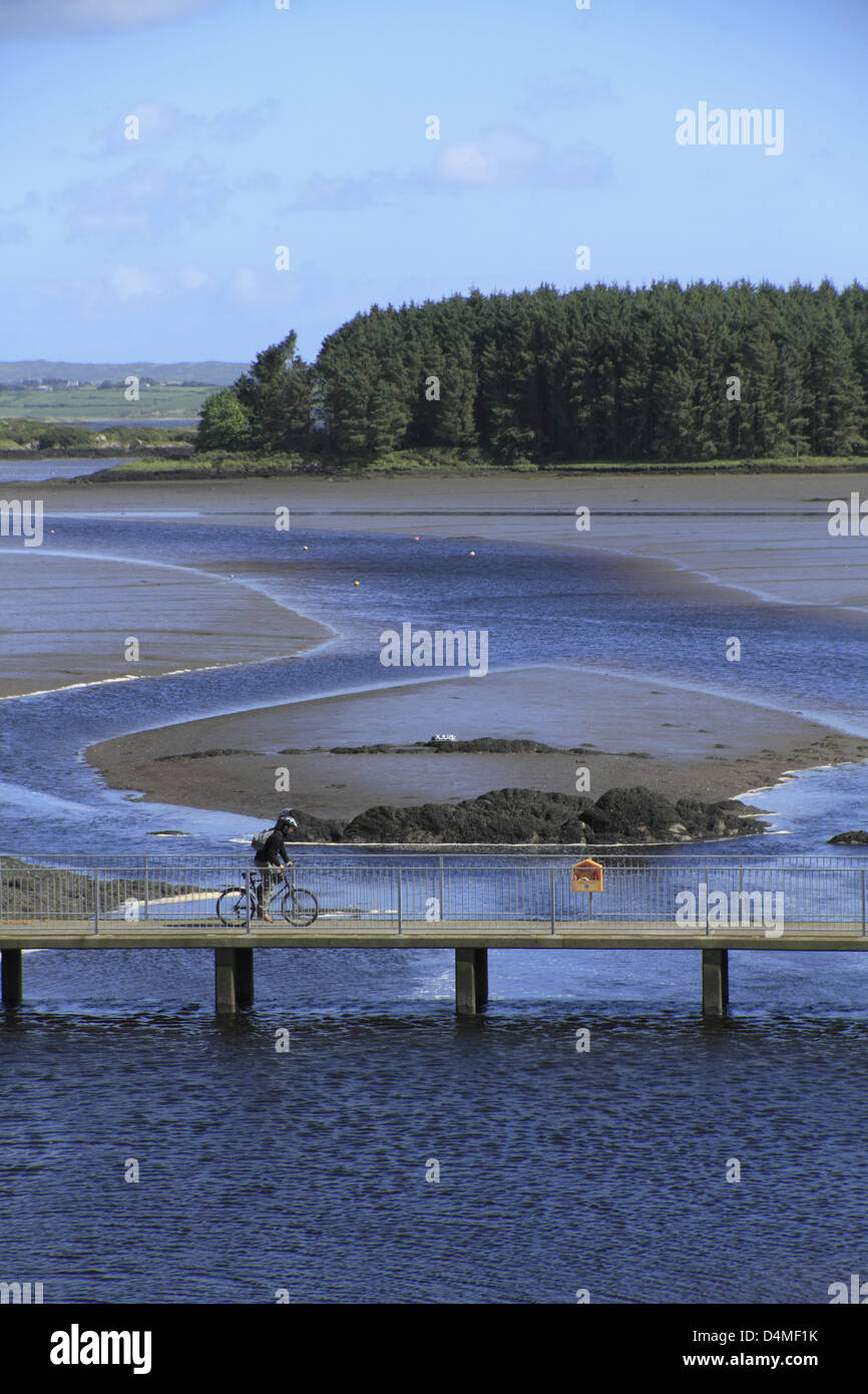 Radfahrer beim Überqueren einer Brücke über die Mündung des Flusses bawnaknockane, ballydehob, West Cork, Republik von Irland Stockfoto