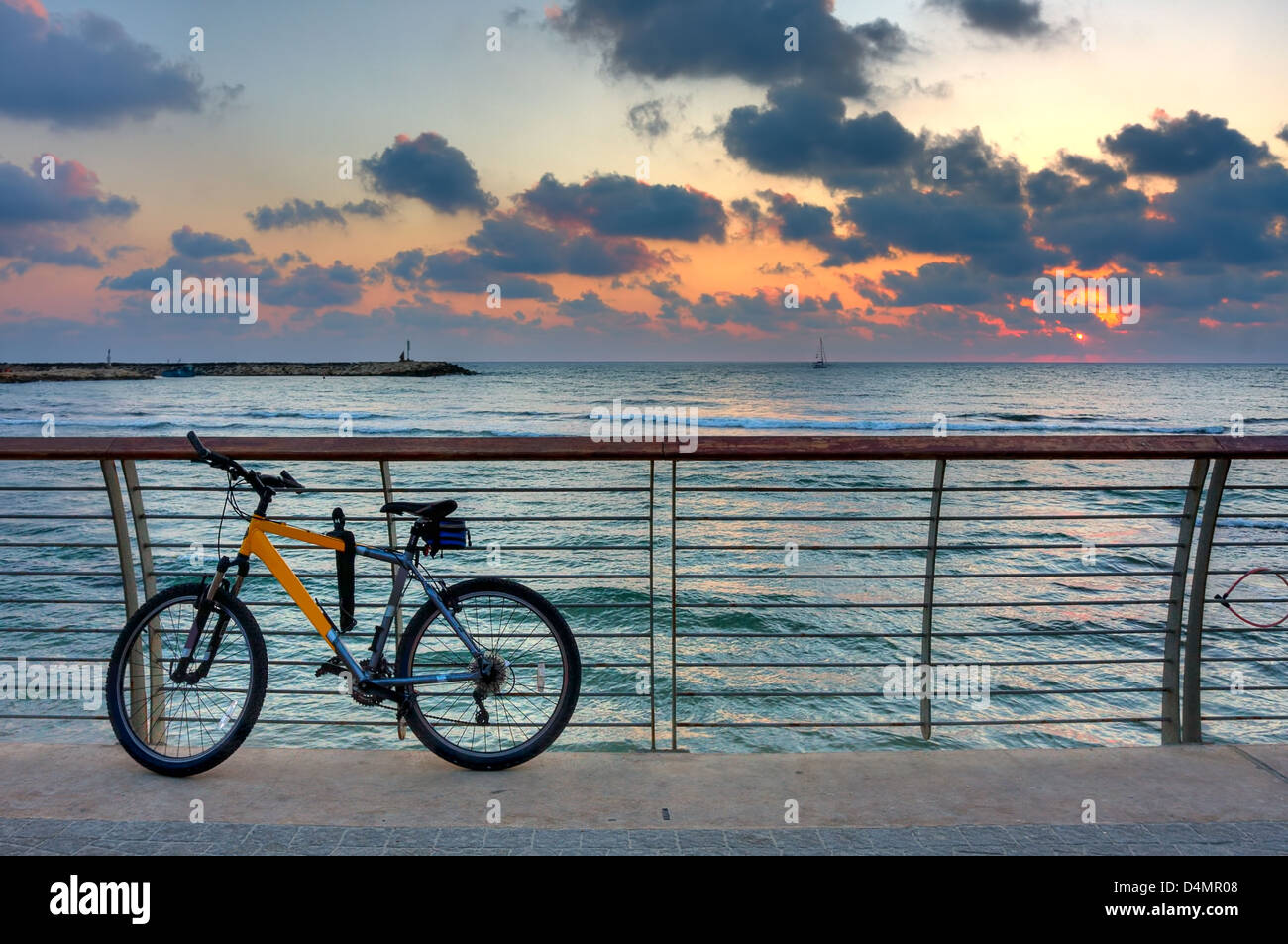Mountain-Bike auf Promenade auf dem Hintergrund von Mittelmeer und schönen Sonnenuntergang Himmel mit Wolken in Tel Aviv, Israel. Stockfoto