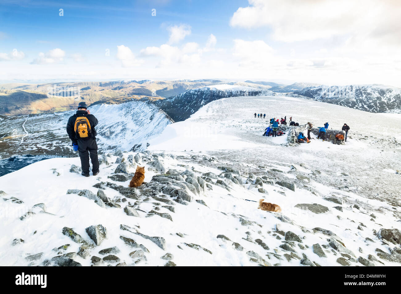 Kletterer, Wanderer und Hunde auf dem Gipfel des Lakelandpoeten im Winter, den Lake District. Stockfoto