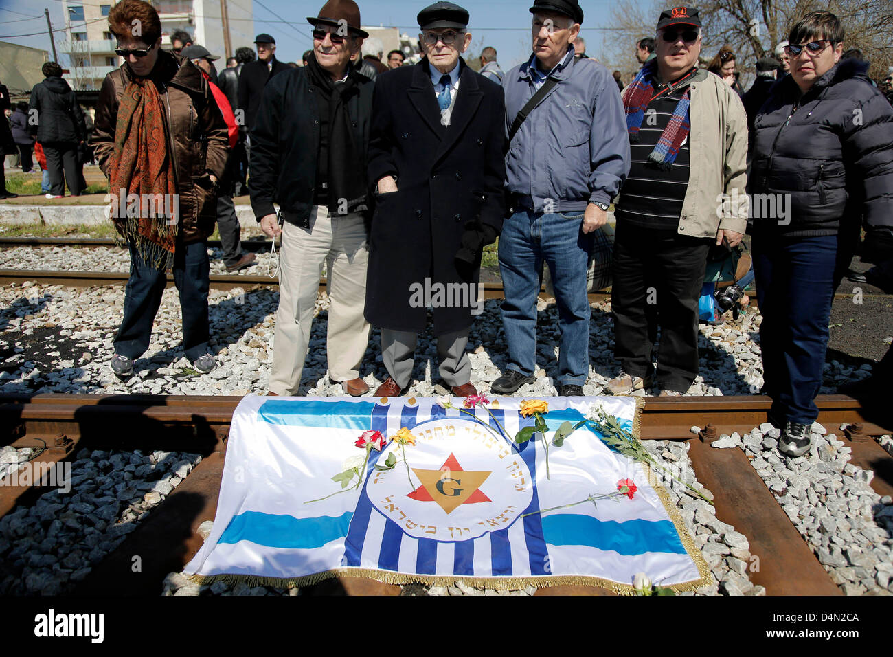 Juden streuen Blumen auf den Schienen des alten Bahnhofs in Thessaloniki, wo der erste Zug Griechenlands Nordstadt unterwegs für das Konzentrationslager Auschwitz am 15. März 1943 verließ. Festschrift März zum 70. Jahrestag von der Abfahrt des ersten Zuges von Thessaloniki zu den Lagern der Nazis in Auschwitz. Start Point, das Holocaust-Mahnmal (Liberty) Eleftherias Square und Ziel der alte Bahnhof, wo der erste Zug mit der Juden von Thessaloniki abgereist. Thessaloniki, Griechenland. 16. März 2013. Zweitgrößte Stadt Griechenlands ist zum Gedenken an den 70. anni Stockfoto