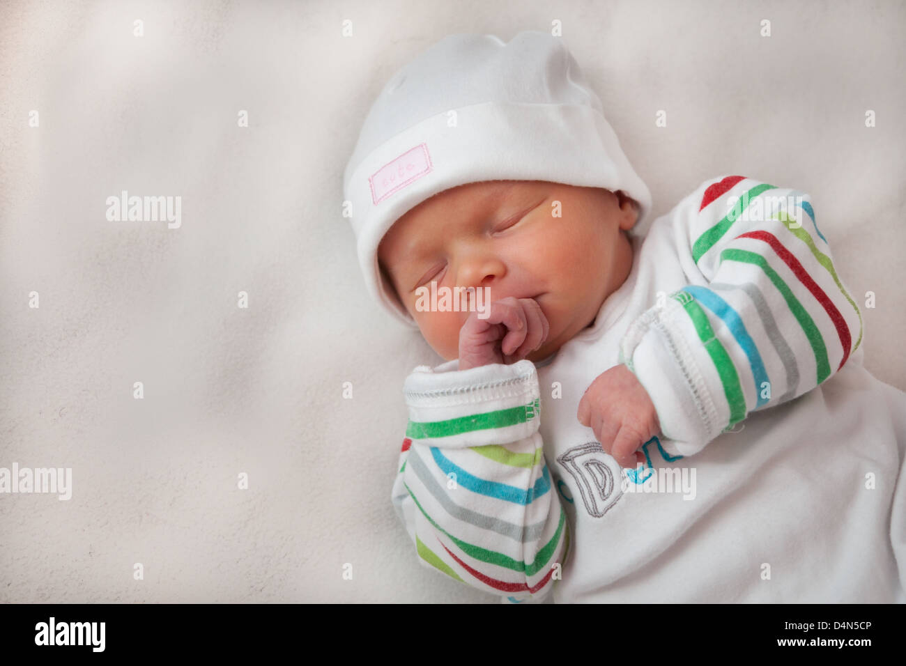 Schöne Mädchen (8 Tage alt) hielt ihre Hände. Ein sehr weiches Licht aufgenommen. Hut liest'süß' und oben liest "I love Daddy". Stockfoto