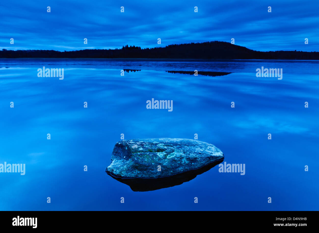 Rock am blauen Wasser des Rådasjön, Schweden, Europa Stockfoto